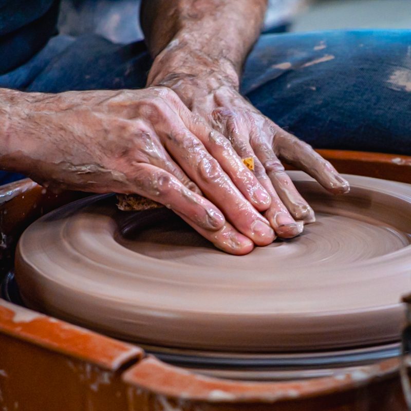 An artisan shaping clay on a pottery wheel